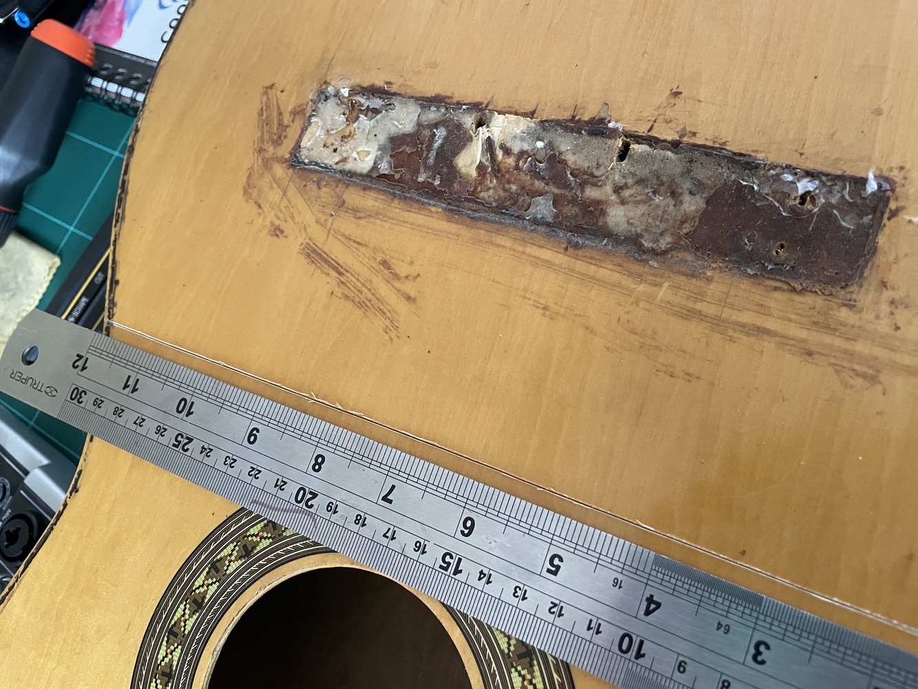 A ruler on the guitar showing where I cut it through