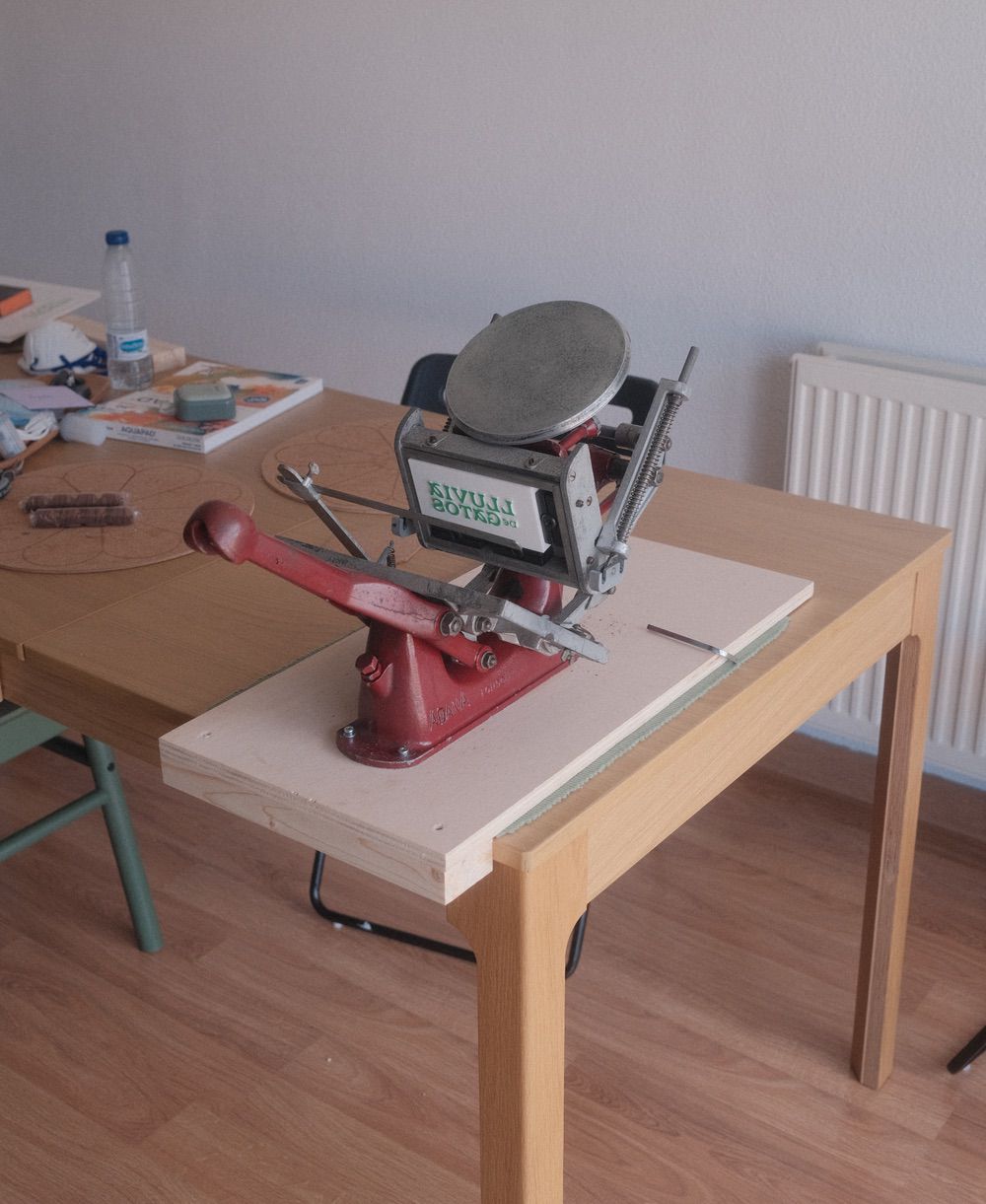 The final press, mounted on a plywood board with a 3d printed block on the chase